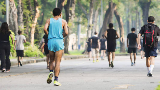 人的后面的看法奔跑和步行在步行花园公园