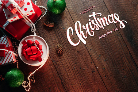 圣诞快乐和新年的题词, 装饰和礼物在一个木褐色的桌子上。圣诞贺卡, 节日背景。混合媒体