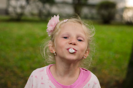 淘气的孩子吹着口香糖泡泡女人用口香糖吹泡泡小女孩与太阳眼镜吹粉红