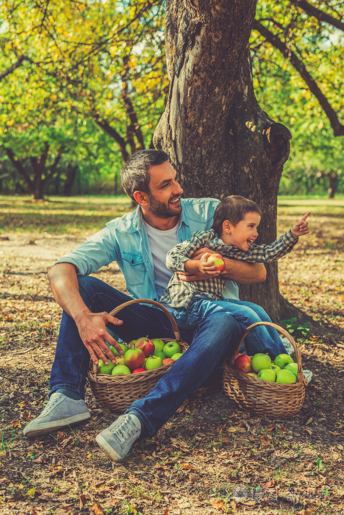 小男孩抱着父亲的苹果