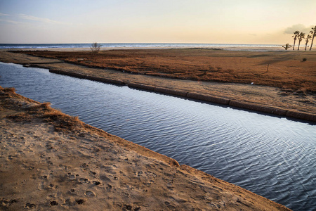 地中海海滩和运河在日落在 Vilanova Geltru, 加泰罗尼亚, 西班牙