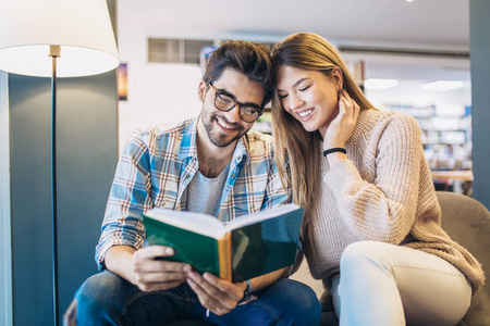 有吸引力的年轻夫妇一起读书在图书馆里