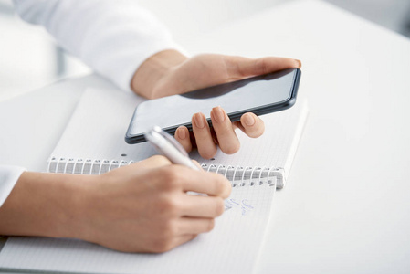 怎么给好友备注在写东西给笔记本时, 女商人手里拿着钢笔和手机的特写