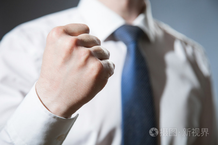 不可识别的商人显示一个强有力的拳头