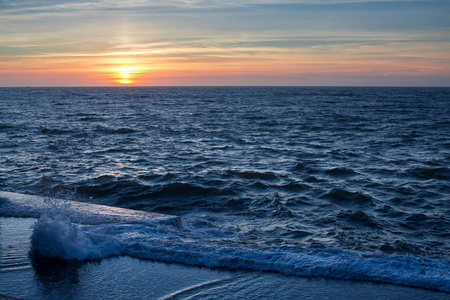 壮观日落时的海滨海洋冲浪
