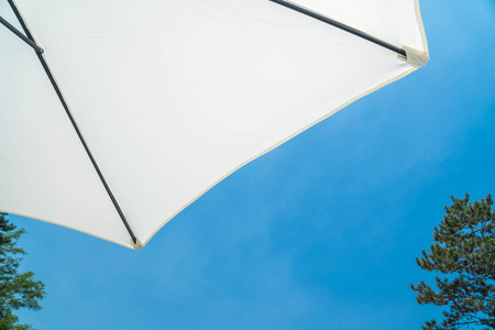 白色在蓝天的背景下打开了沙滩伞