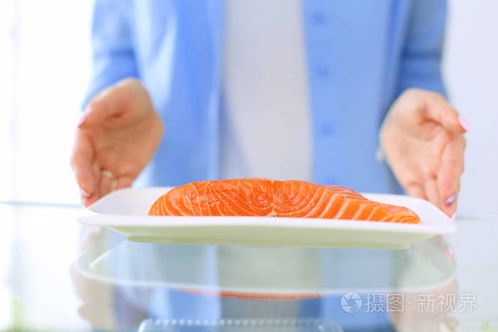 女性站附近打开冰箱充分的健康食品，蔬菜和水果的画像。女性肖像