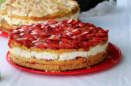 美味的新鲜草莓芝士蛋糕在盘子上的桌子上