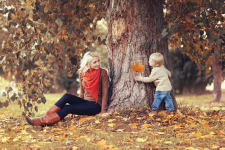 在秋天的公园里的家庭啊!妈妈和儿子的孩子一起玩照片