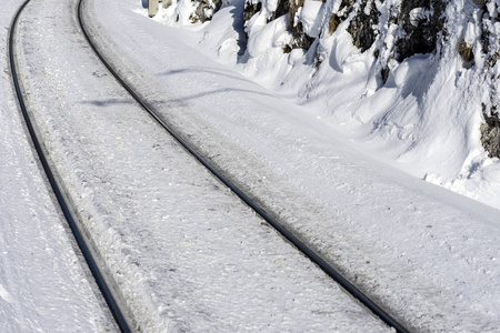 大雪中的铁路线。铁路穿越冬季的性质。寒冷的阳光明媚的日子里的火车轨道