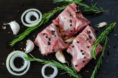 生肉类与草本和黑胡椒, 在黑暗的背景, 香料周围