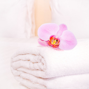 干净的毛巾与兰花在床上