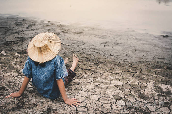 哀伤的女孩和用尽在破裂的干燥地面, 概念干旱和缺水危机