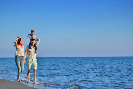 年轻的家庭在海滩上找到乐趣