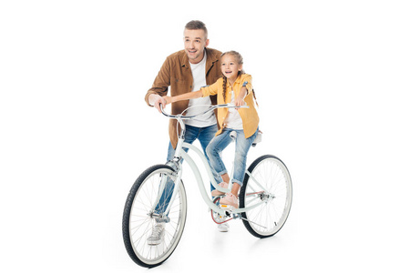微笑的父亲和小女儿在自行车孤立的白色