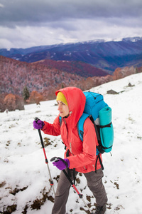 在山区雪上行走，背包里的女孩