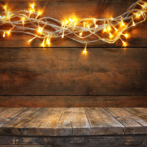 木工板桌板上木制仿古的温暖金花环灯。过滤后的图像。选择性的焦点