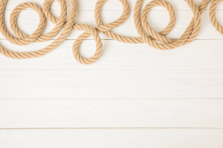 白色木质背景上棕色航海绳索的顶部视图