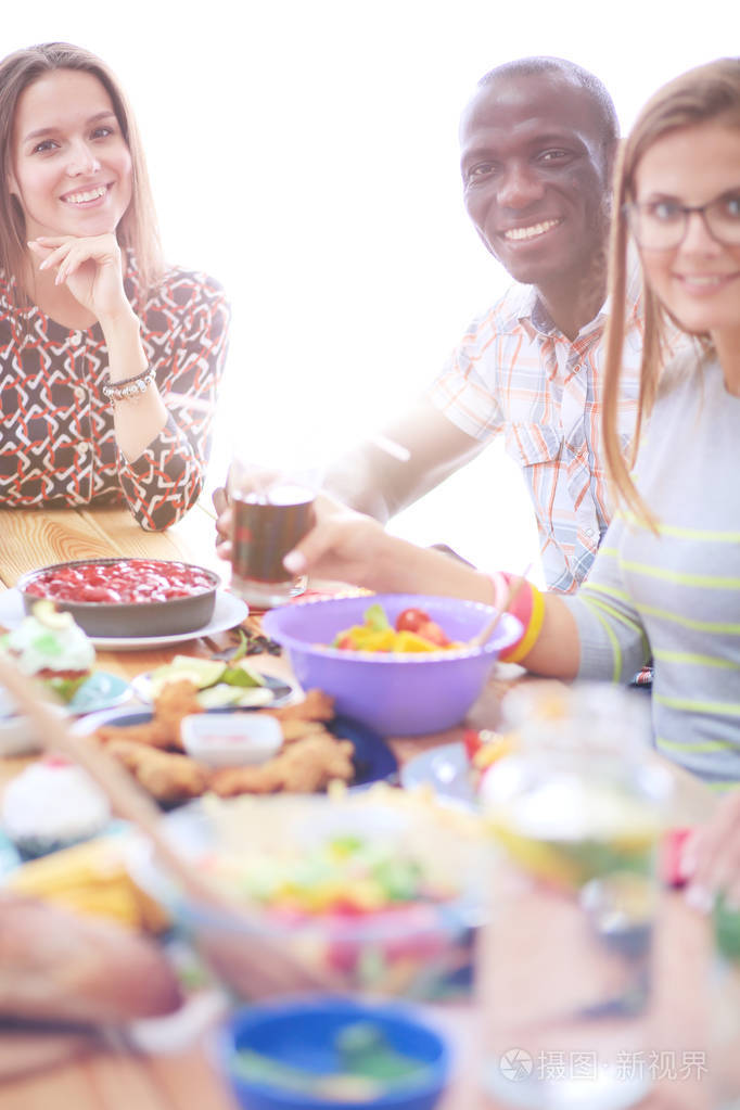 顶视图的一群人在一起时坐在木桌吃饭.在桌子上的食物.人们吃快餐