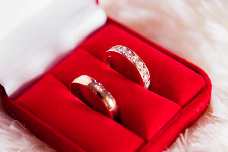 金色结婚戒指与钻石在红色礼品盒。爱情与婚姻的象征