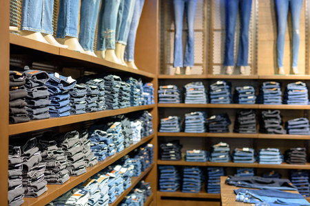 每日精品不同整齐的折叠牛仔裤在商场的货架上的商店照片