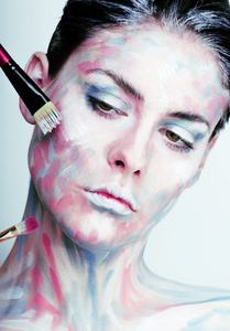 年轻女人有创意化妆像脸上涂的油图片