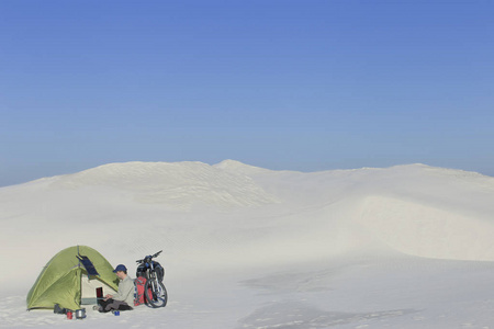 骑着自行车在沙漠中旅行的人