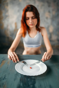 不幸的年轻妇女反对板用片剂为重量损失