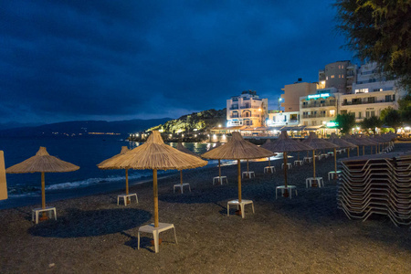 希腊克里特岛尼科斯 Agiolaos 的茅草沙滩檐篷和照明建筑