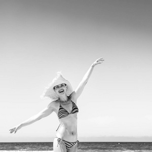 蓝海, 白沙乐园。快乐的现代女人在海滩和稻草帽子在海边