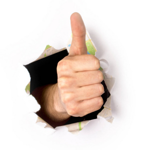 通过拇指通过隔离在白色背景上的纸孔竖起大拇指照片