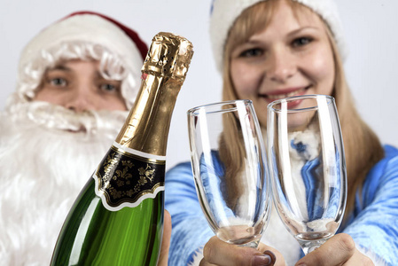 圣诞老人和雪姑娘拿着一瓶香槟