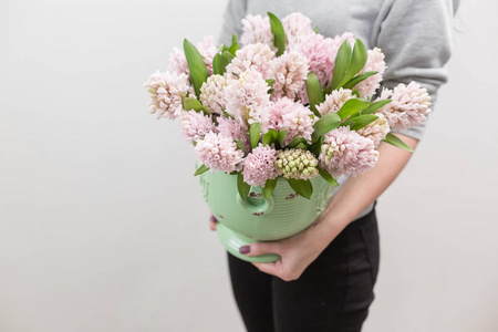 一束美丽的粉红色风信子.春天花在花瓶在妇女手.球茎植物.