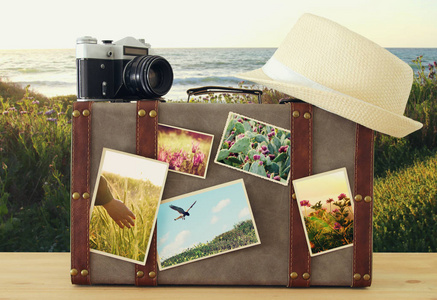 旧古董行李, 软呢帽帽子和老式旧照片相机与自然照片在木地板上的形象