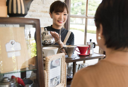 女服务员浇注茶在杯中