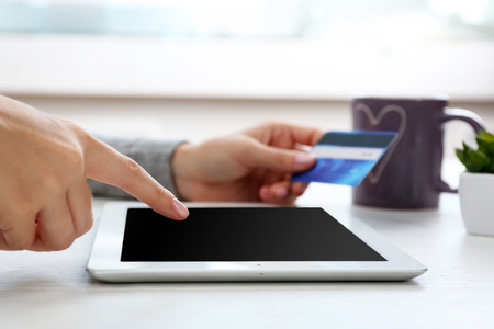 互联网购物的概念 数字平板和信用卡的双手
