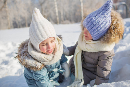 在冬天的雪地里玩耍的两个小女孩画像