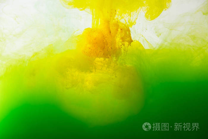 从灰色看水中绿色与黄色颜料飞溅的混合