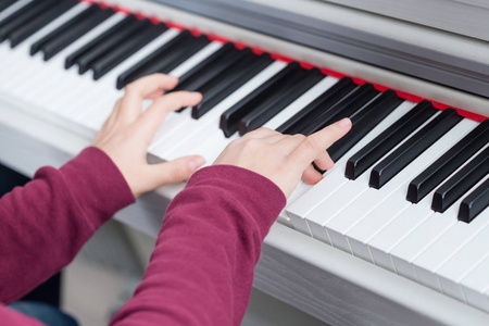 小女孩的手接近钢琴弹钢琴