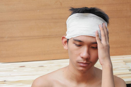 头部外伤的年轻人。由医用绷带