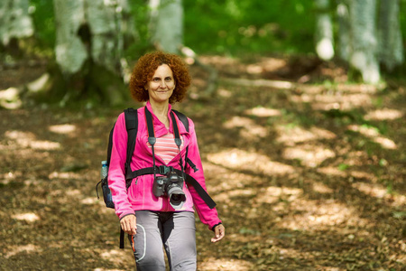 女人自然摄影师与专业相机和背包