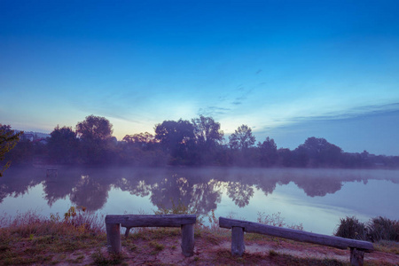 清晨, 黎明越过湖面。日出前平静的湖面。一个朦胧的早晨, 乡村的风景, 沙漠, 神秘的感觉