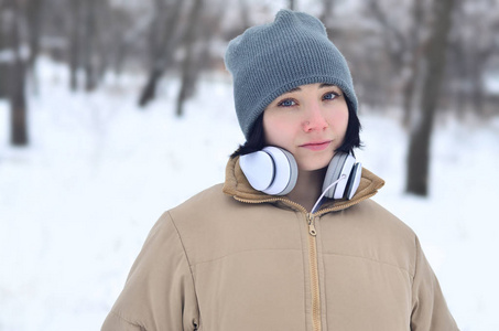 冬天的年轻女孩戴着耳机的肖像
