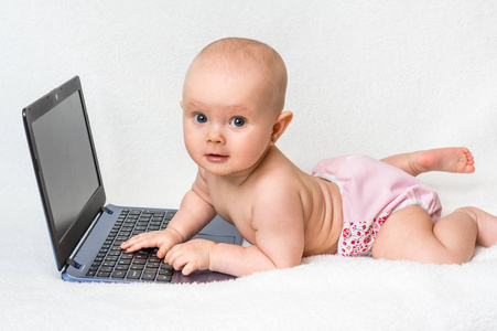 在上白色孤立的手提电脑上打字的可爱的小宝贝