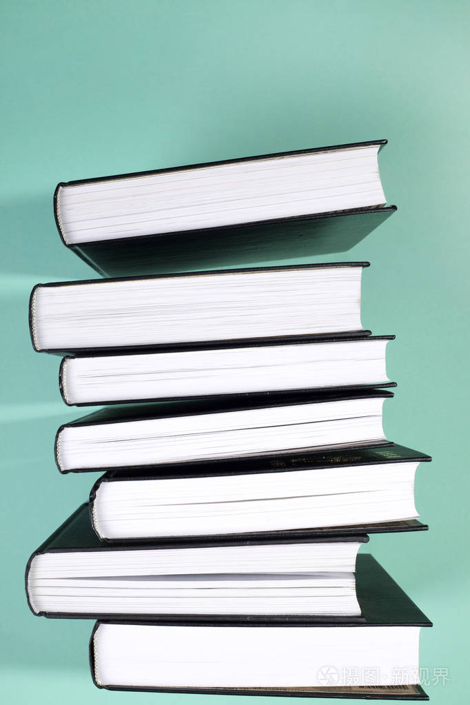一堆书在绿色背景侧面视图