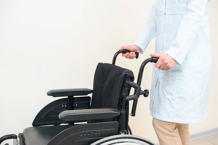 女性医生与轮椅在白色裁剪镜头