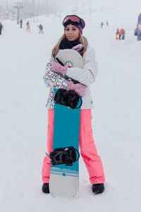 与山为背景的滑雪板女孩