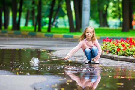 在秋天公园大水坑里开心的小快乐女孩
