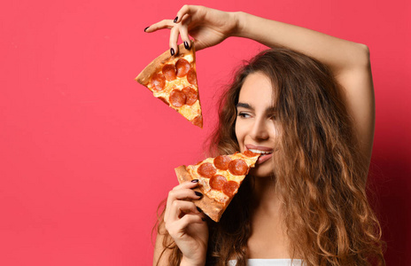 年轻美丽的妇女吃片香肠比萨微笑在深红色