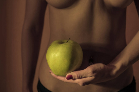 饮食的概念。女性腰部和苹果的背景下的女人的身体。健康的生活方式